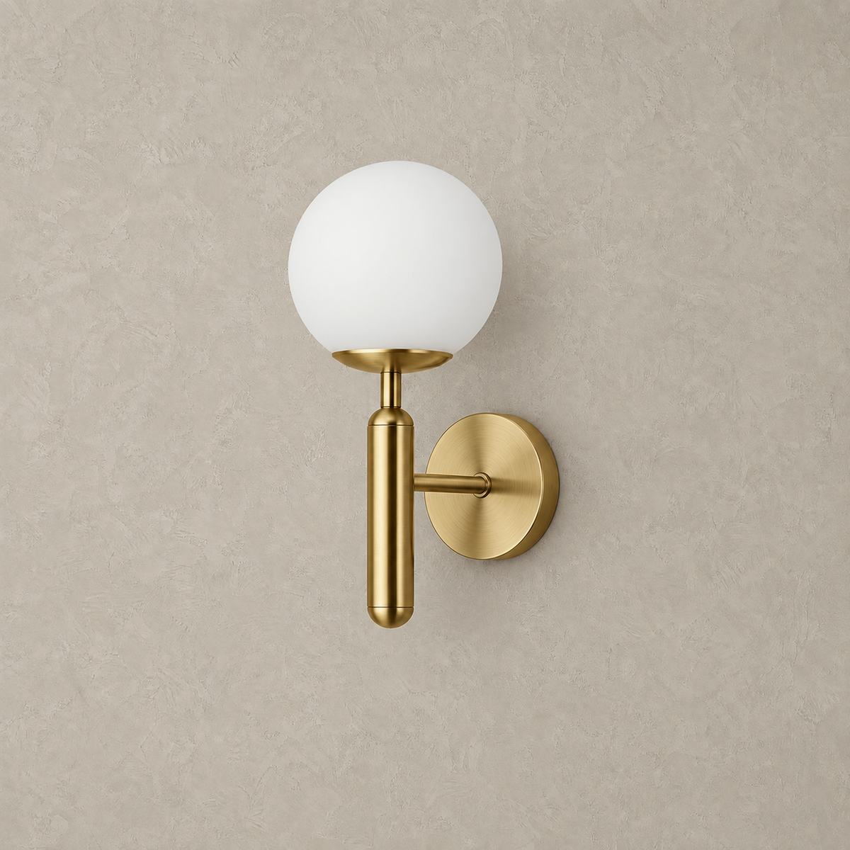 Vesilan gold and white plug in wall sconce, unlit frosted globe shade on a plaster wall