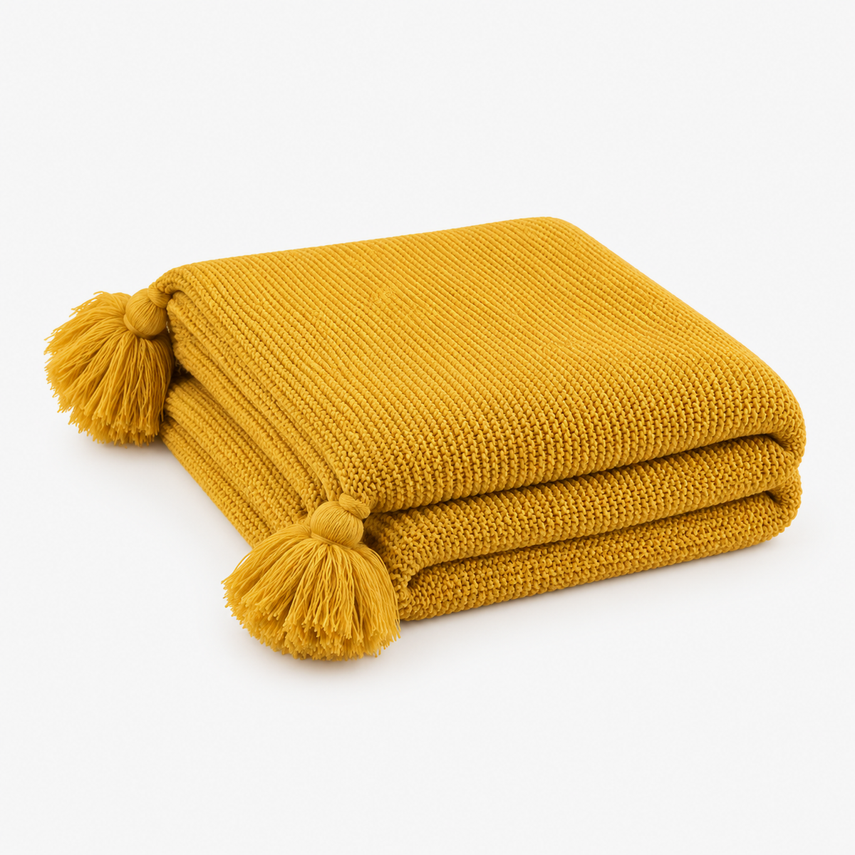 Vesolmi mustard knit throw blanket loosely folded with tassels at the corners