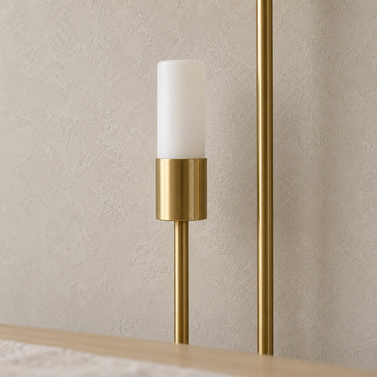 Amolven gold wall sconce close view of an unlit cylindrical head and arm in a dining room