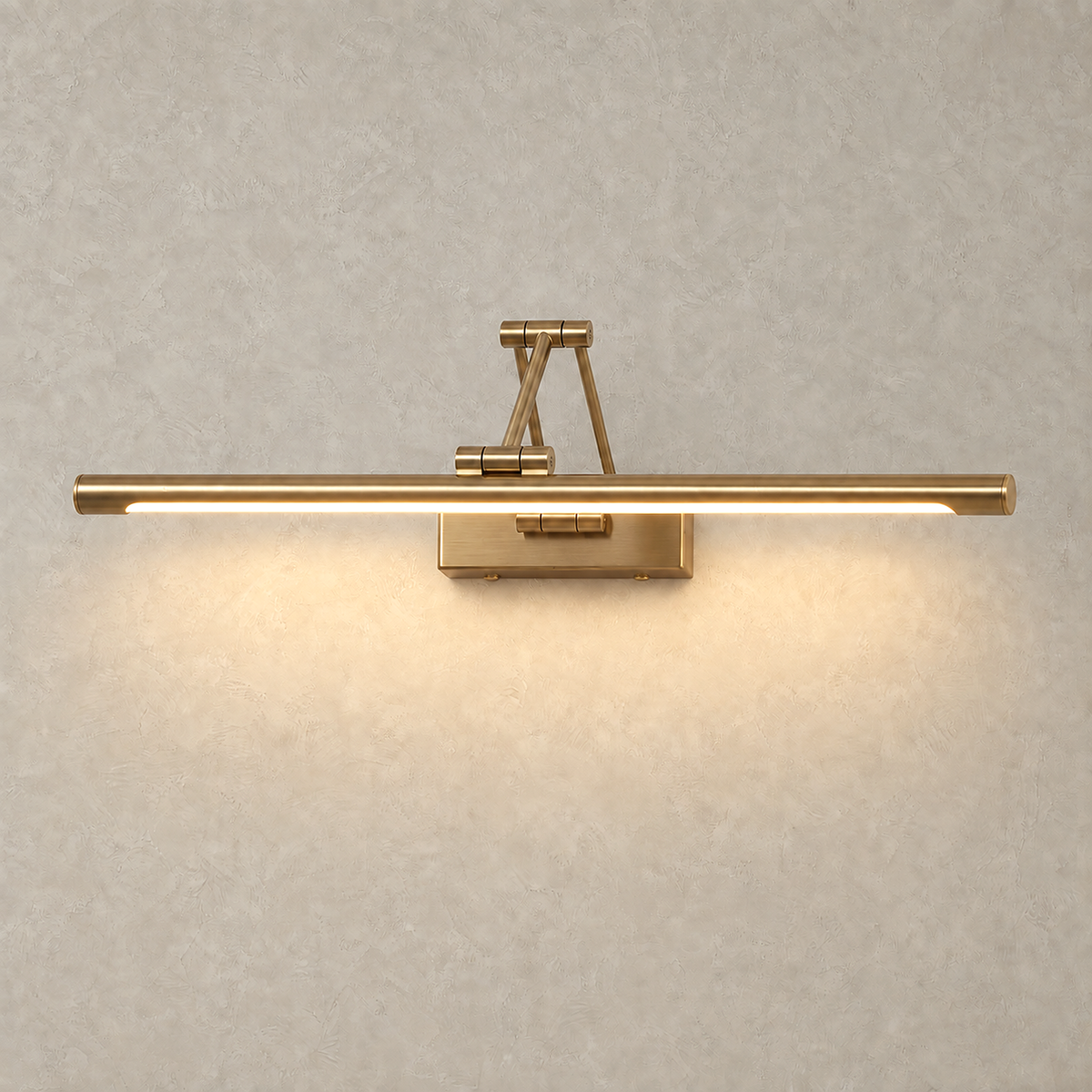 Anterilo gold LED wall sconce switched on with a warm downward wash on greige plaster