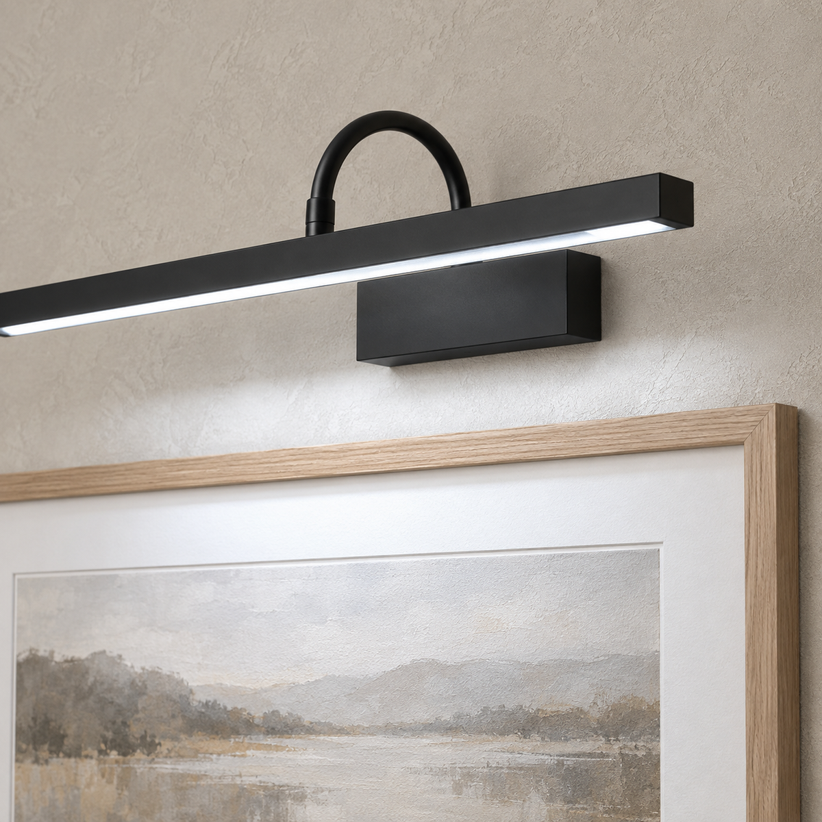 Anvelio black LED wall sconce with its compact base casting light onto framed dining room art