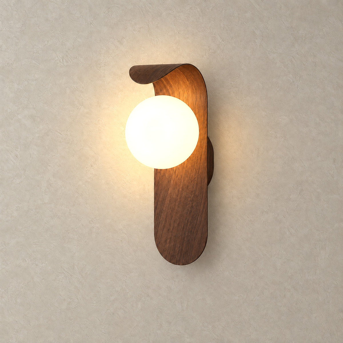Arcelmo walnut hardwired wall light with its globe glowing warm white on a plain backdrop