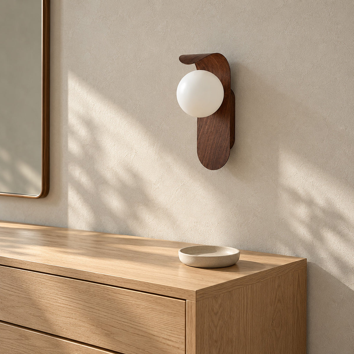 Arcelmo walnut wall lamp, unlit beside a dressing chest in a daylit dressing room