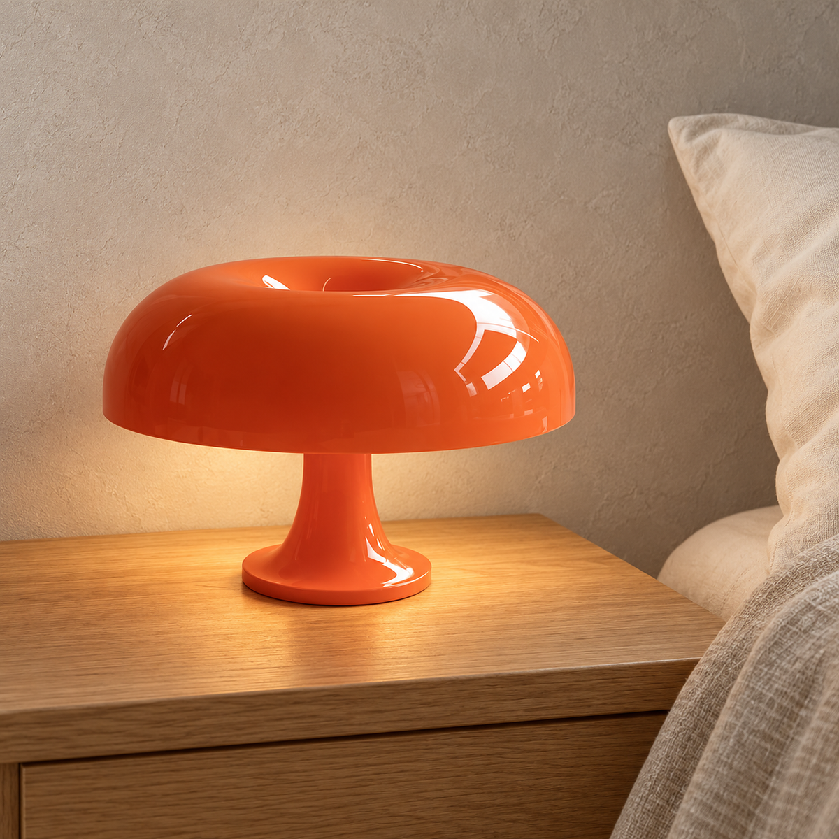 Camolire orange bedside lamp glowing warm beside an ivory pillow in a loft sleeping alcove