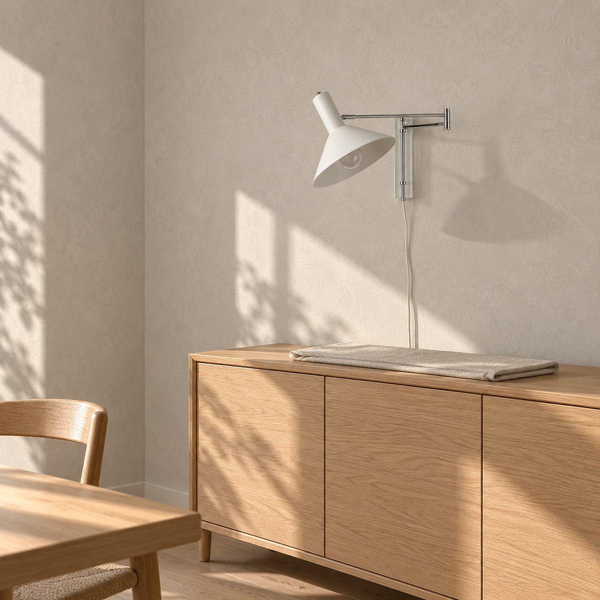 Celmoira white wall sconce unlit above a sunlit sideboard in a dining room