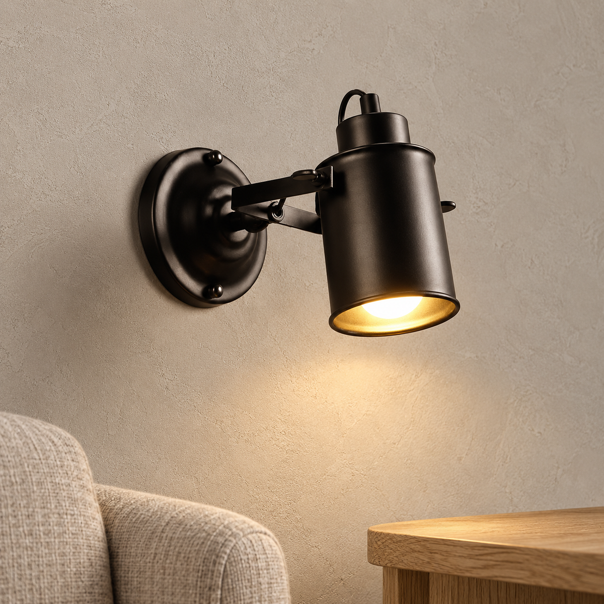 Cerimalo black plug in wall lamp lit above a clear side table in a sunny reading corner