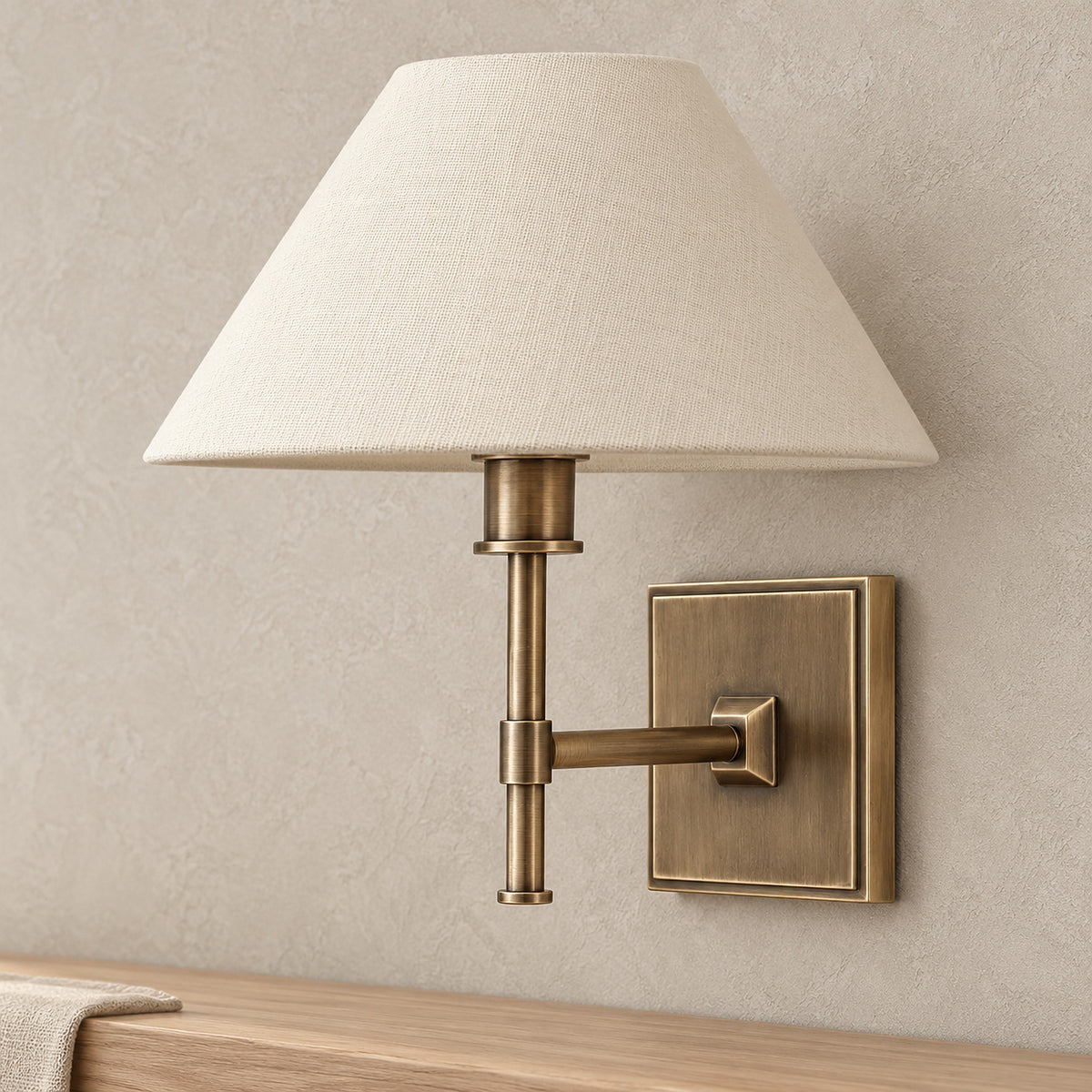 Ciralmo gold battery operated wall sconce, close up of the fabric shade and forged body in a gold finish
