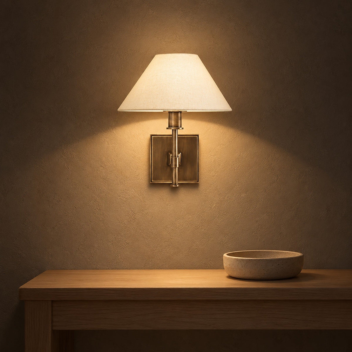 Ciralmo gold wall lamp with fabric shade lighting an entry vestibule at night
