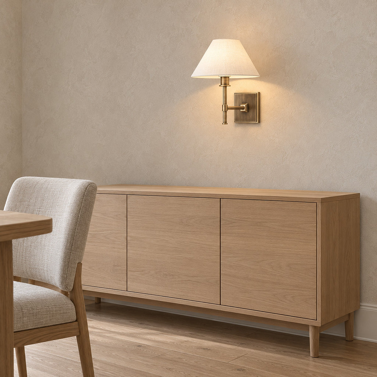 Ciralmo gold wall light side view lit above a dining sideboard in daylight