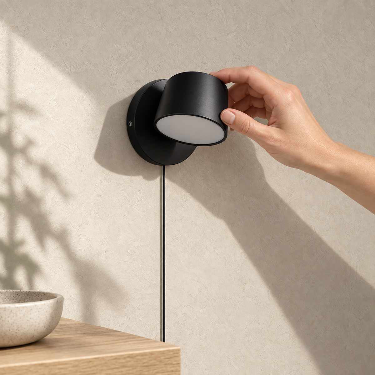 Cirelvo black single head LED wall sconce unlit in a sunny entry alcove by day