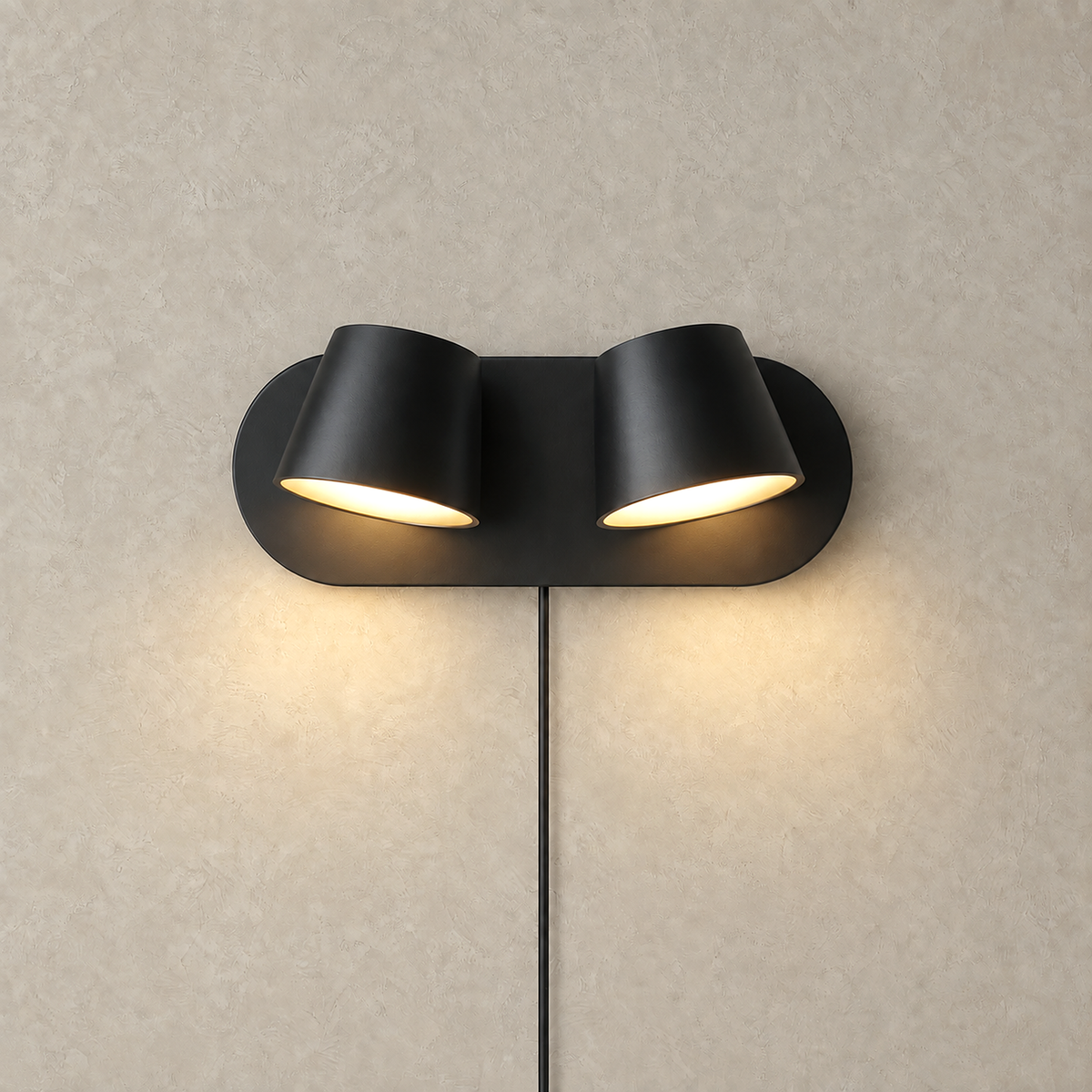 Cirelvo black two head LED wall sconce casting warm light on a plain studio plate