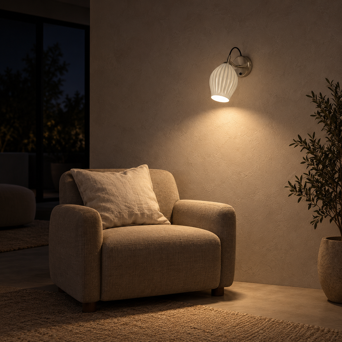 Comirel chrome wall light casting downward light over an armchair at night