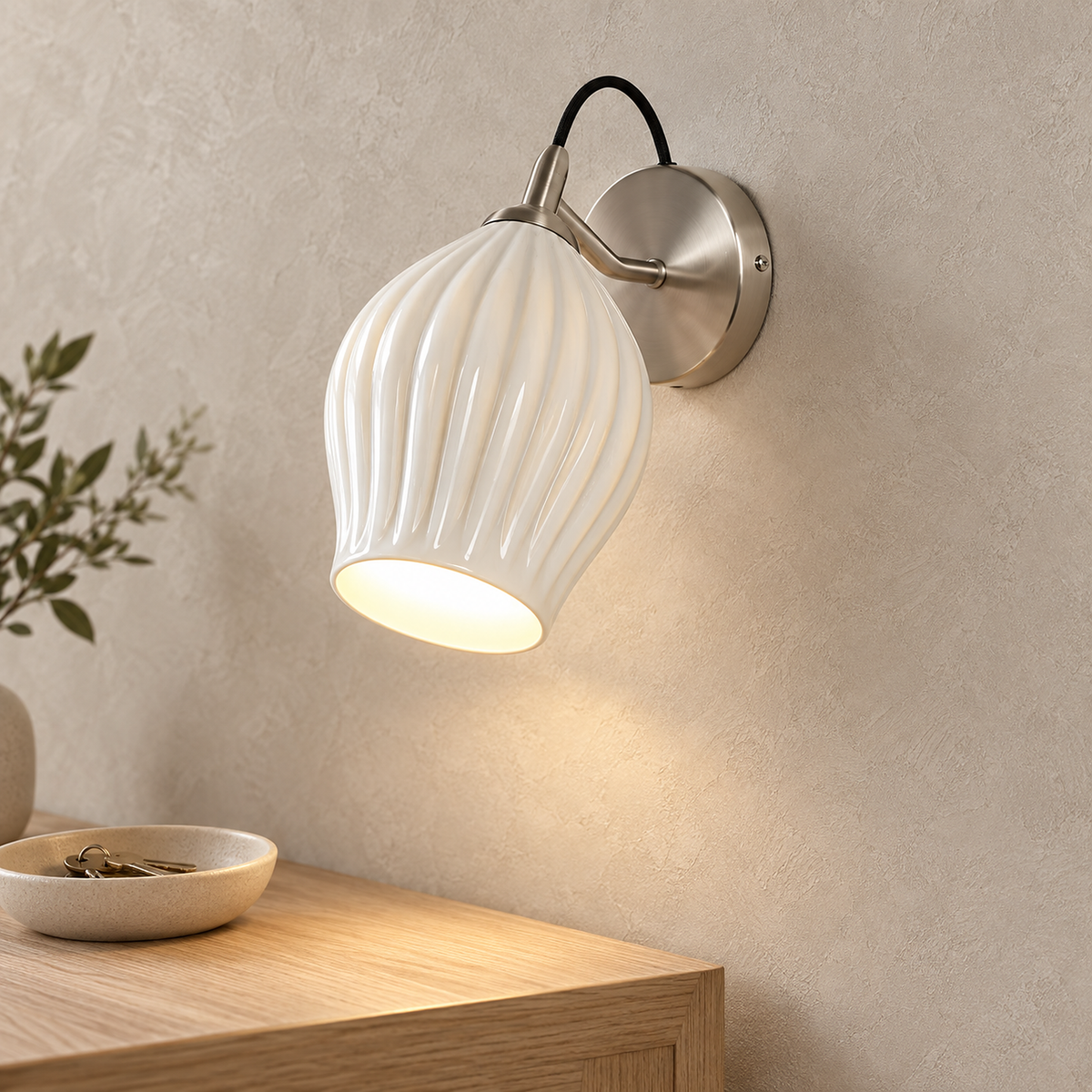 Comirel chrome wall light glowing above an entry console in daylight