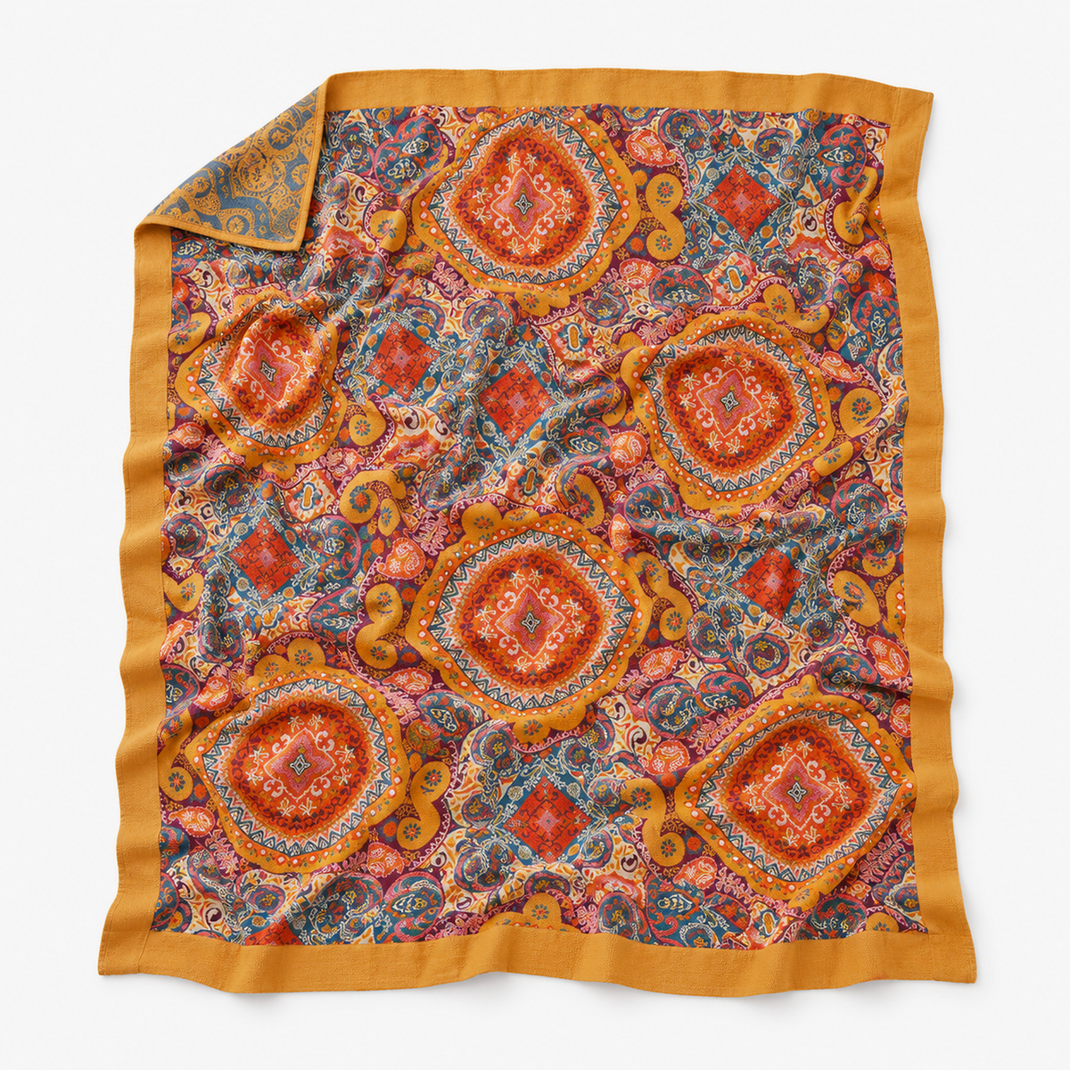 Corameli orange red and teal blue cotton jacquard blanket laid open flat with its full mustard border