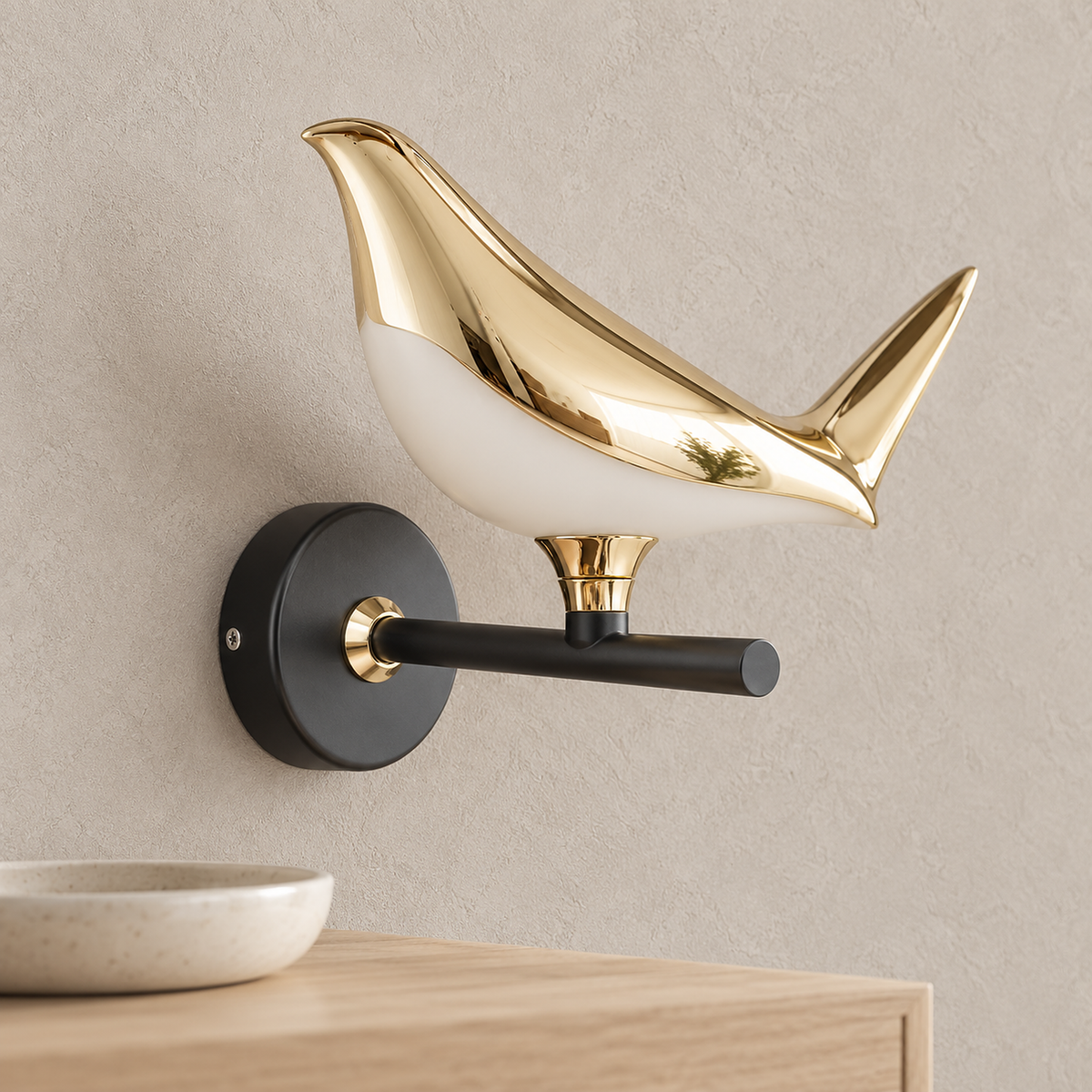 Corsavel 1 bird gold and black wall lamp up close, showing the plated aluminum bird and pale acrylic shade