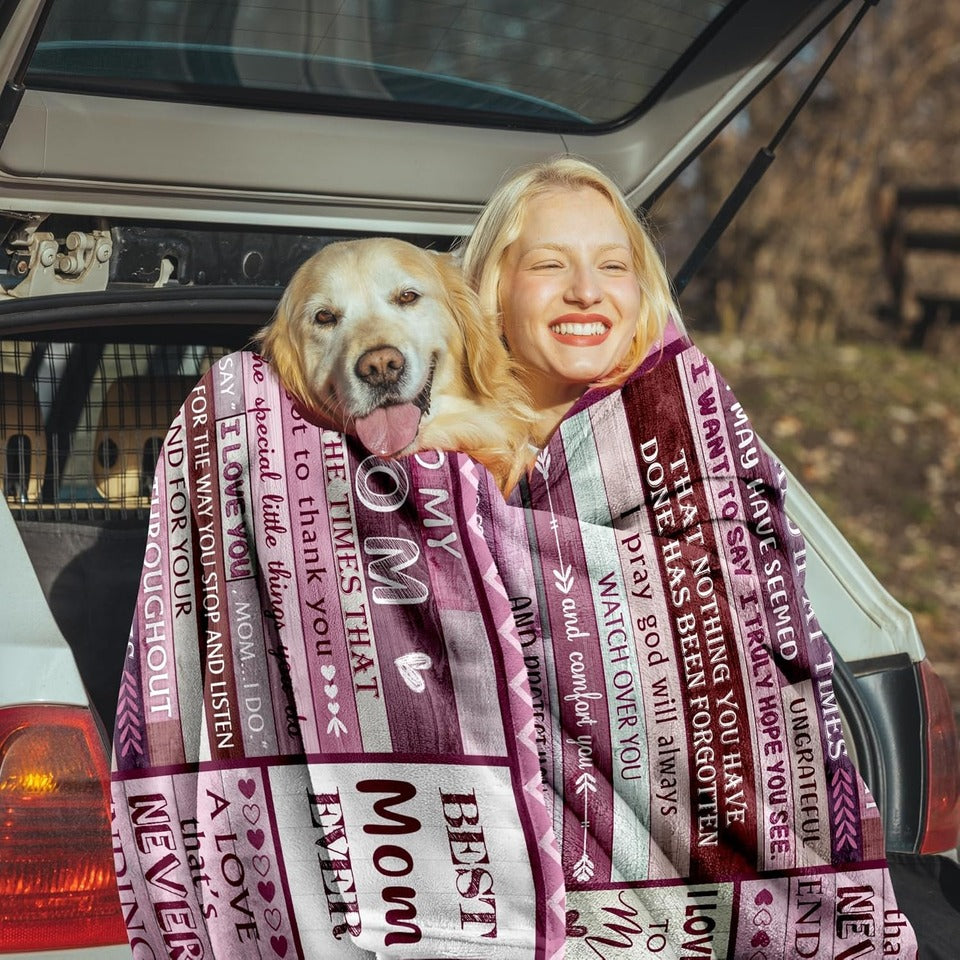 Elmisa mom fleece throw blanket draped around a woman and dog in an open car trunk, showing pink text panels.