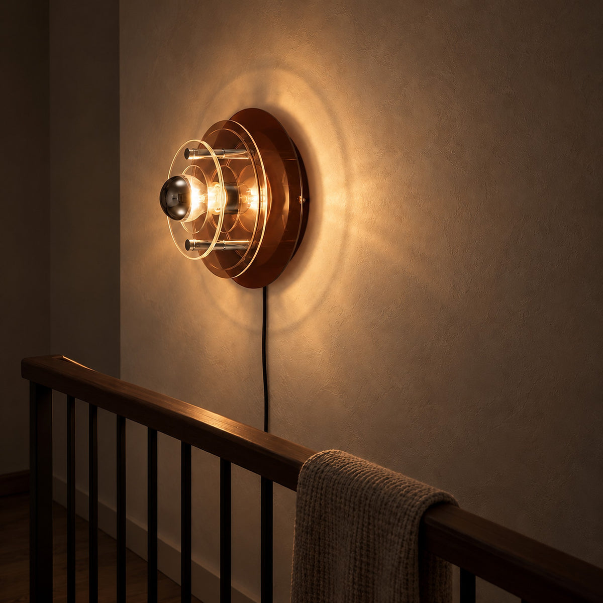 Elsarvo brown wall sconce illuminating a landing after sunset with broad halos on the wall