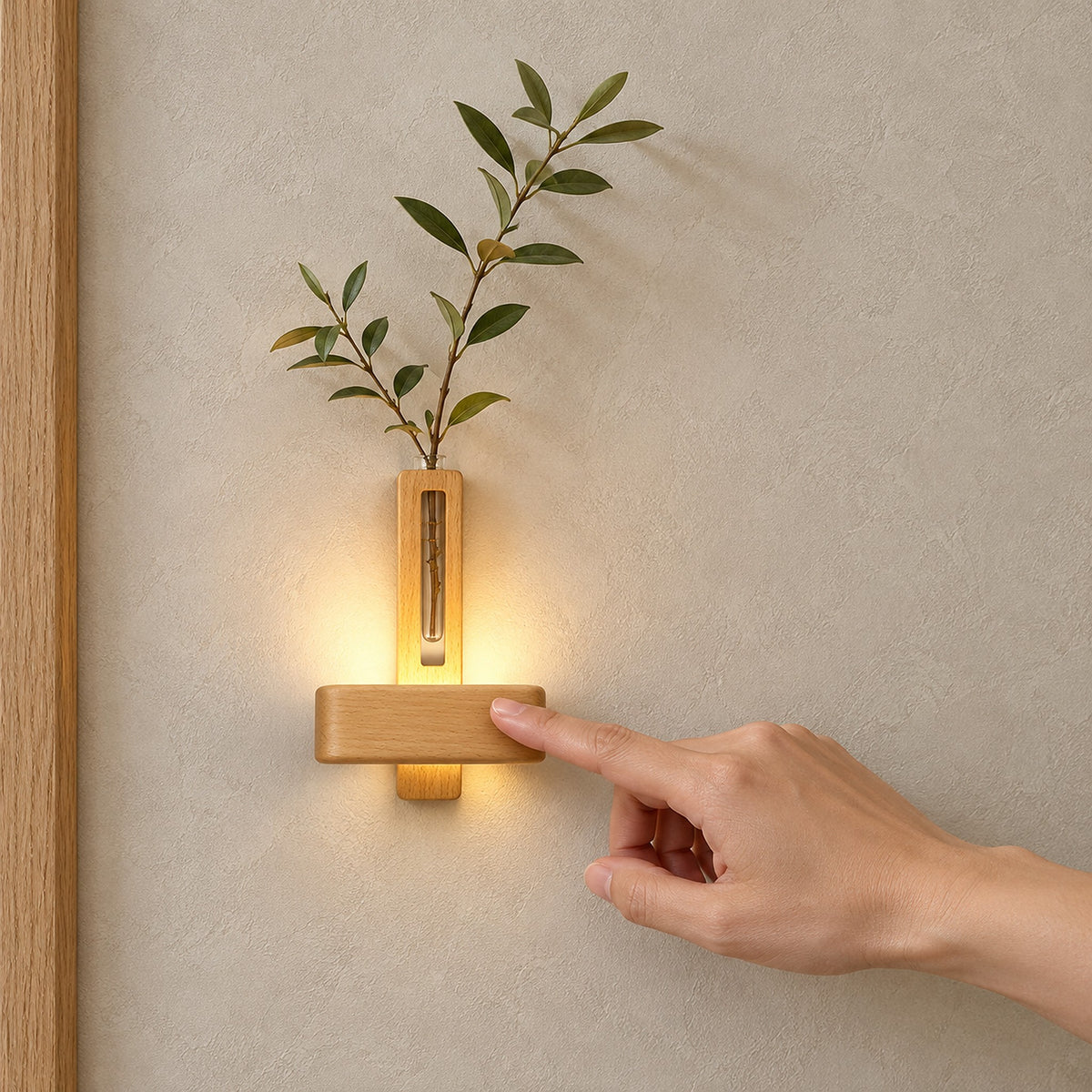 Ilaveno Natural wall light holding leafy stems on a textured wall, with a hand touching the illuminated bar