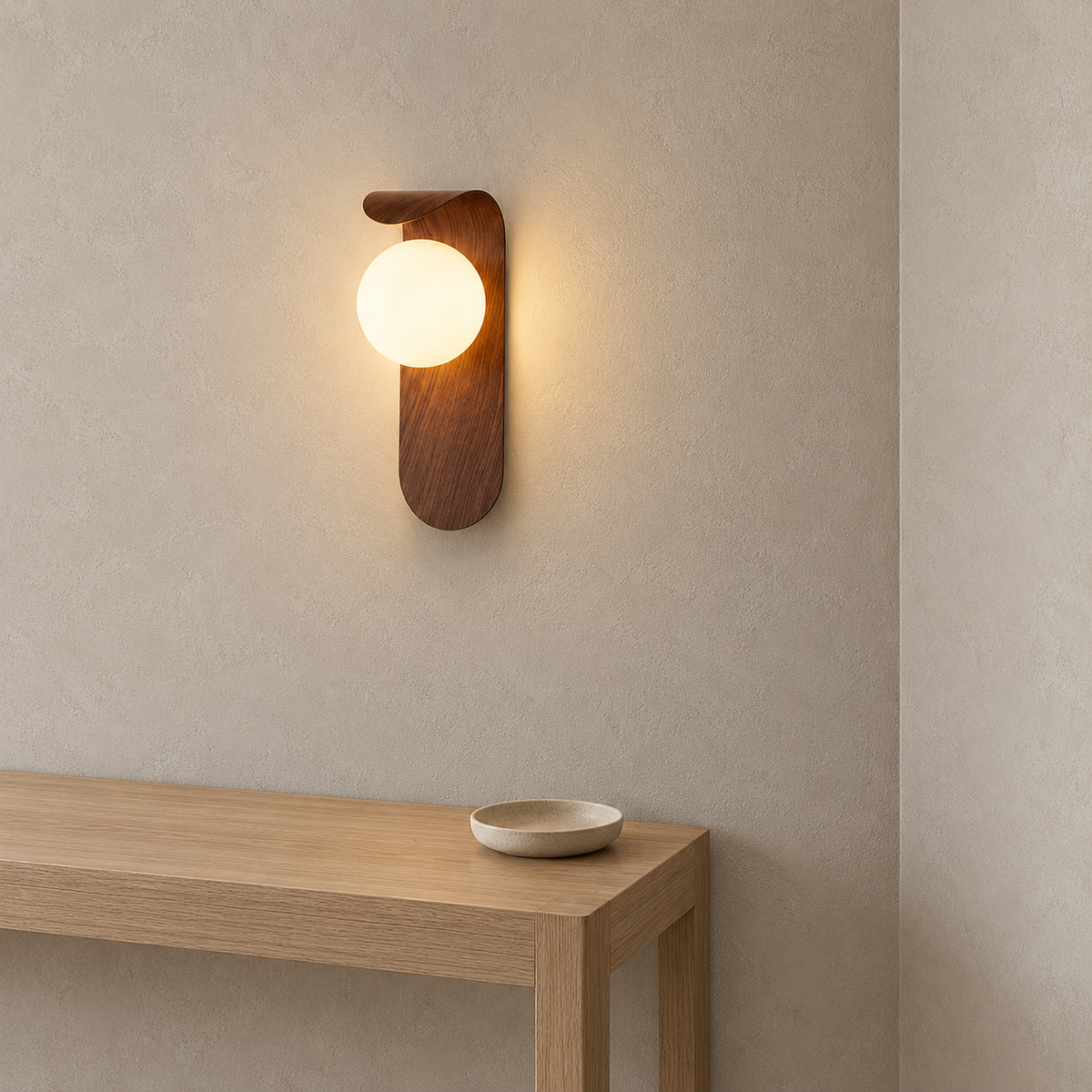 Ilvarne walnut wall sconce seen from the side, showing the lit globe and curved backplate