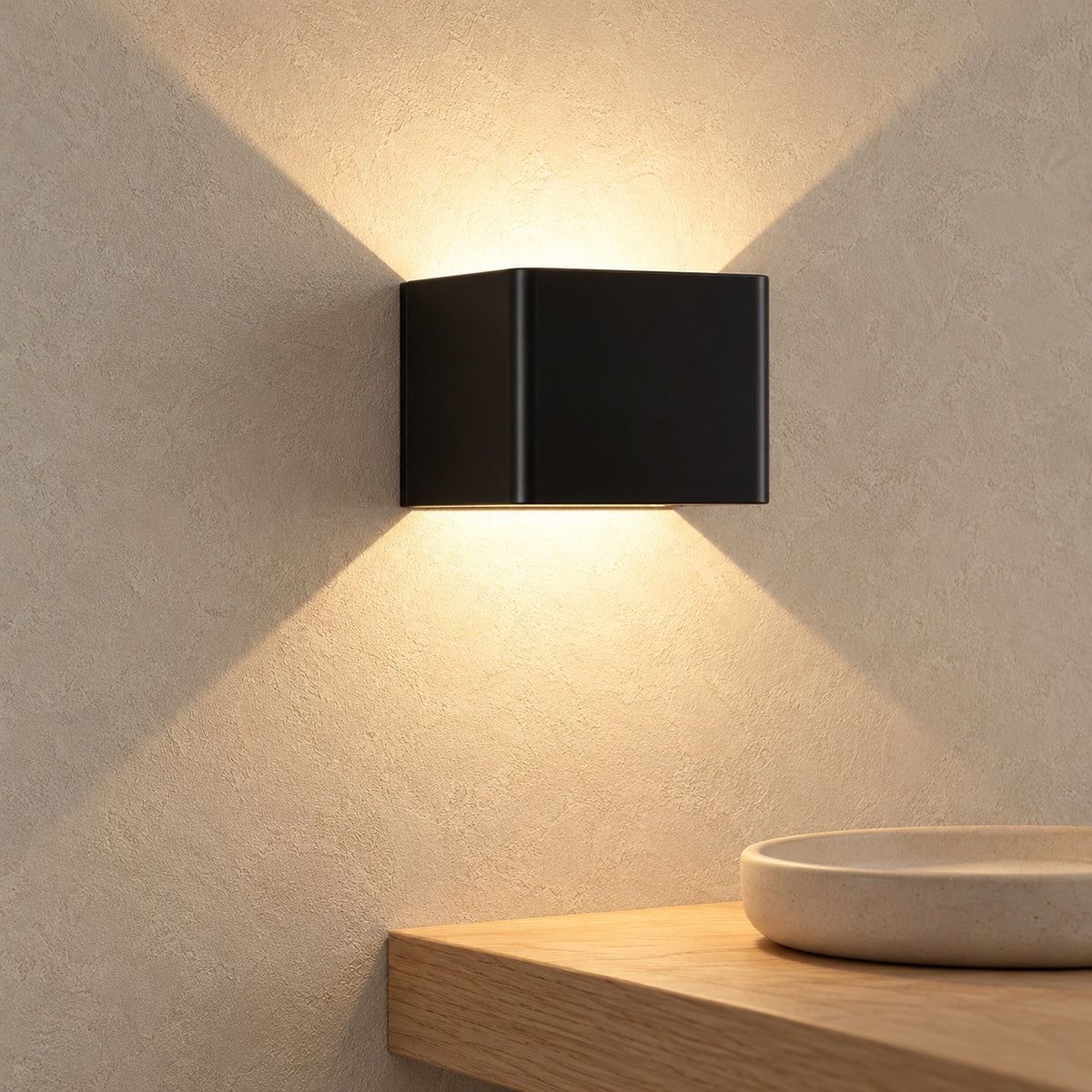 Ivelmo black cordless wall lamp glowing with warm light above an entryway shelf by day