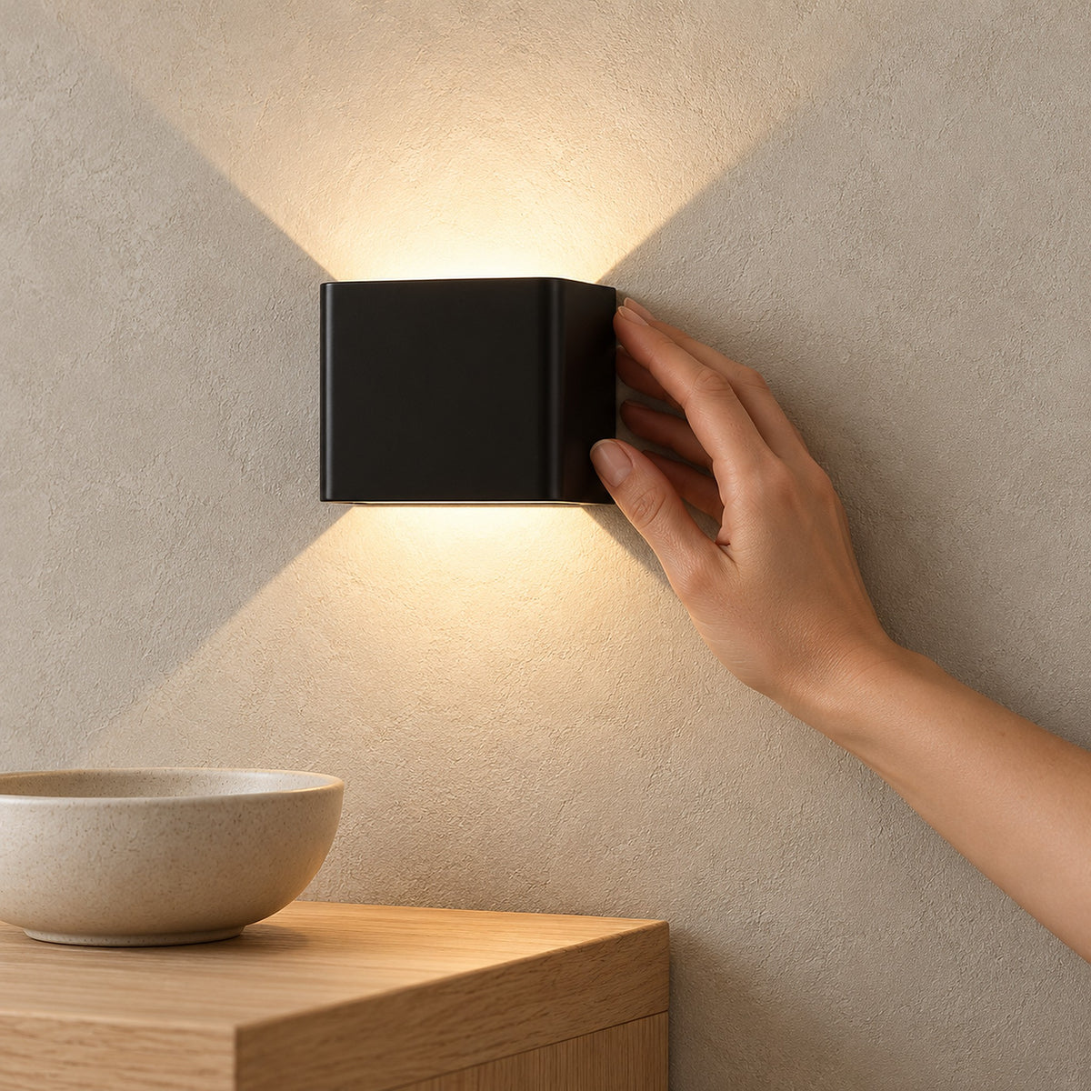 Ivelmo black wall lamp shining warm light above the corner of a dining room sideboard