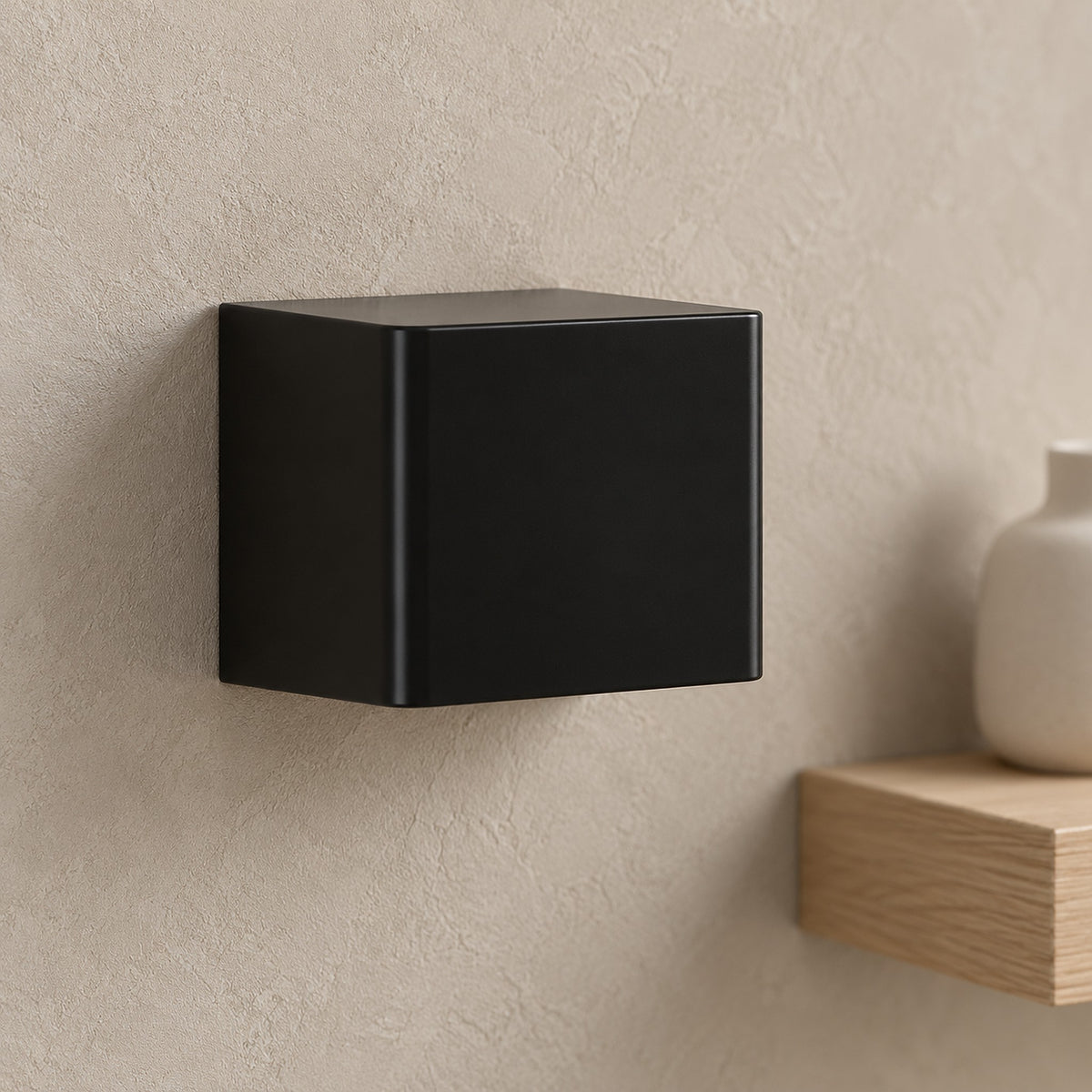 Ivelmo black wall sconce up close, showing the plastic housing texture and rounded edge