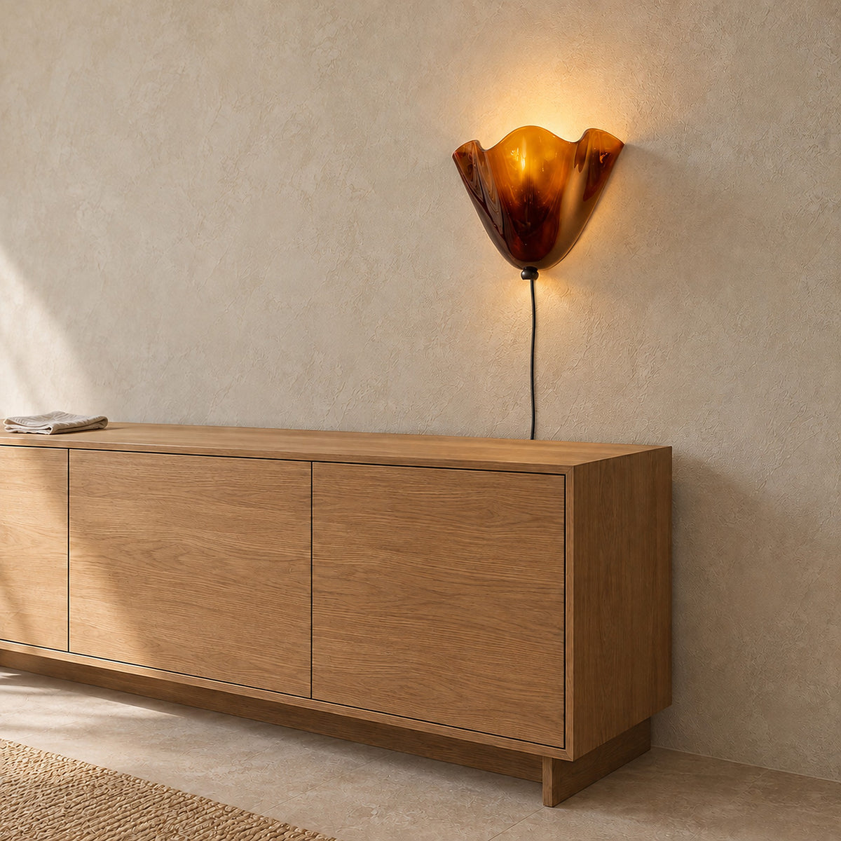 Lanorvi brown glass wall light lit above a dining room sideboard in daylight #color_brown