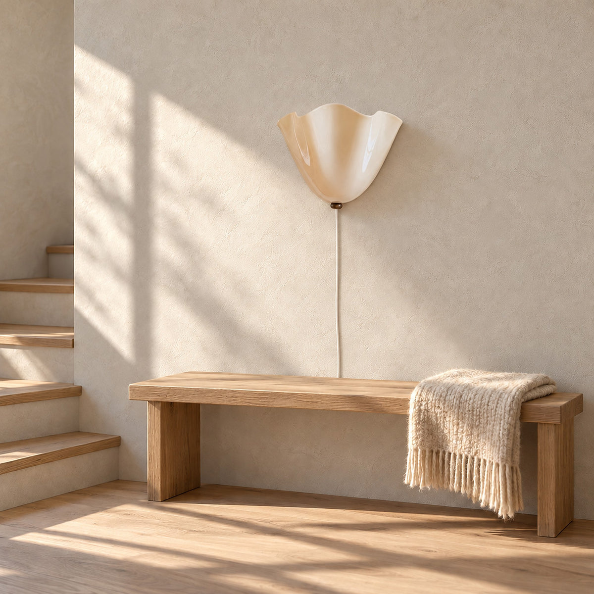 Lanorvi ivory glass wall lamp, unlit, on the wall of a sunlit stair landing