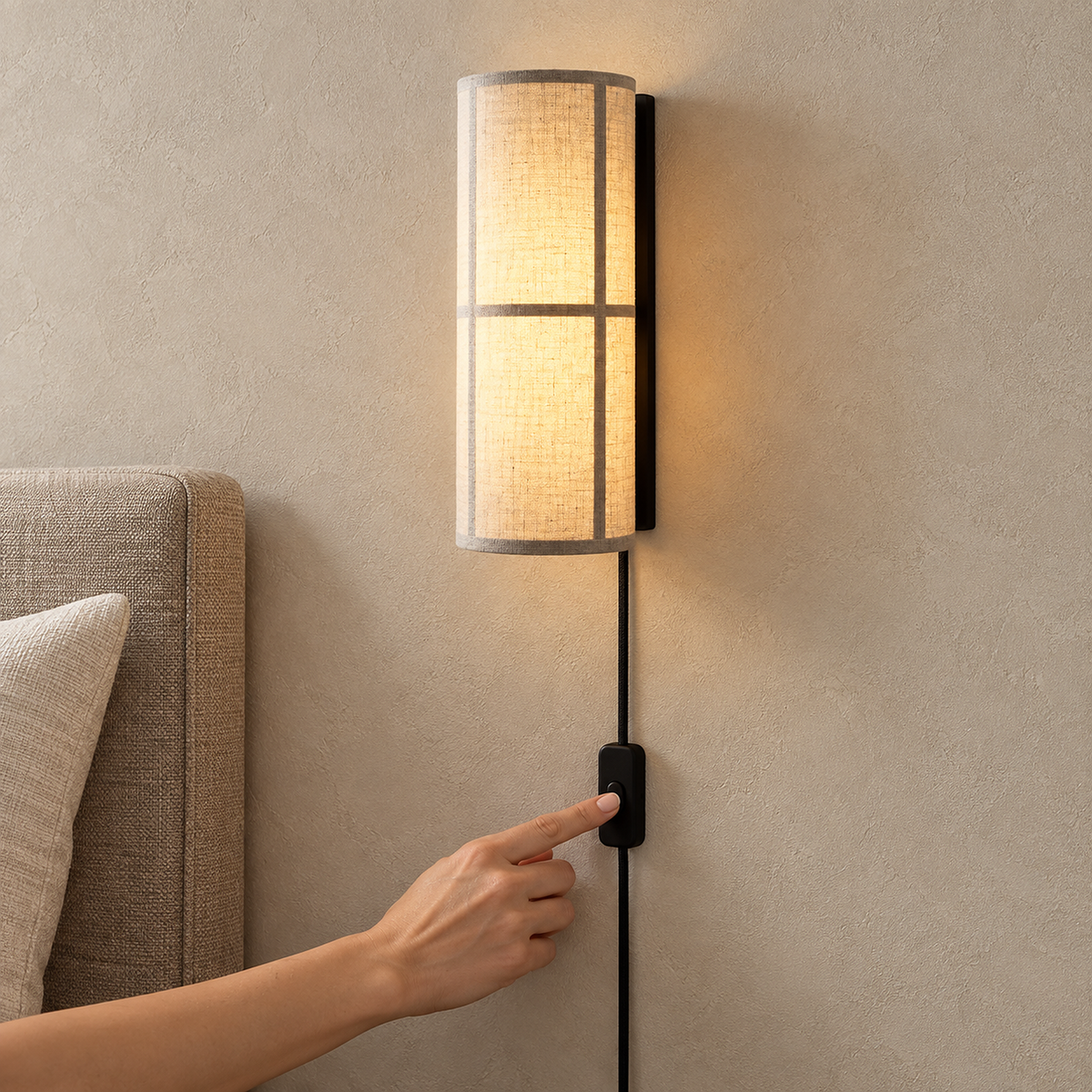 Lassivor white plug in wall sconce lit with its inline push button switch visible on the cord