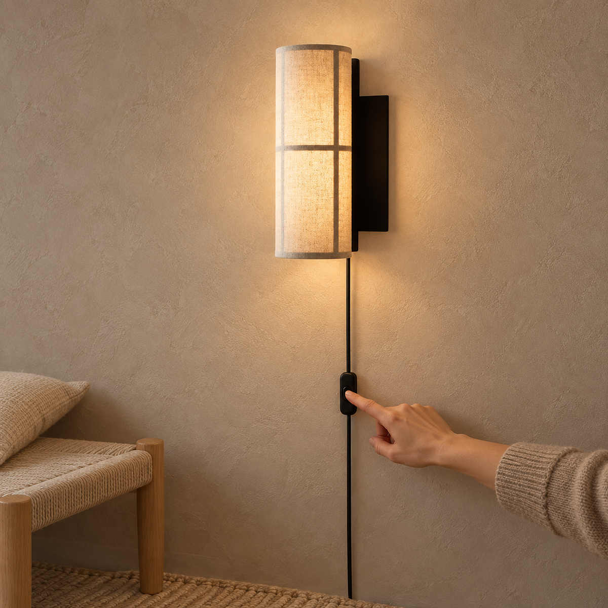 Lassivor white wall lamp lit in a hallway with its cord hanging down to the outlet
