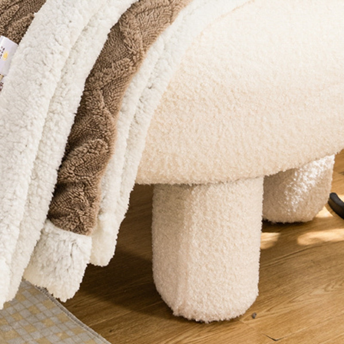 Lerivosa reversible fleece throw blanket draped over a cream chair, showing brown fleece and cream trim.