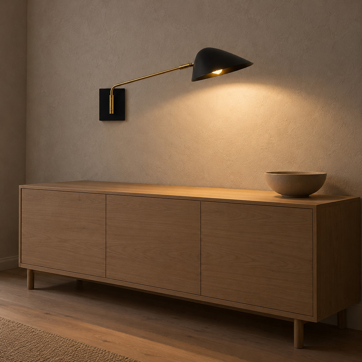 Lirmena black hardwired wall sconce glowing as it projects from the wall above the dining furniture