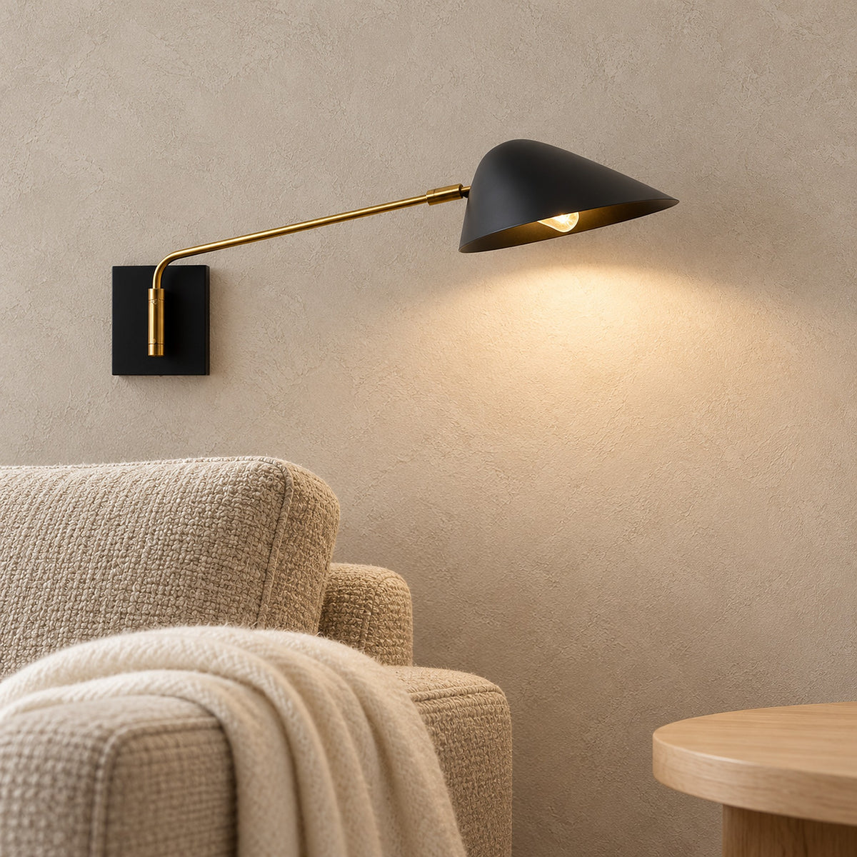 Lirmena black wall lamp glowing warm white beside an oatmeal armchair in a bright living room