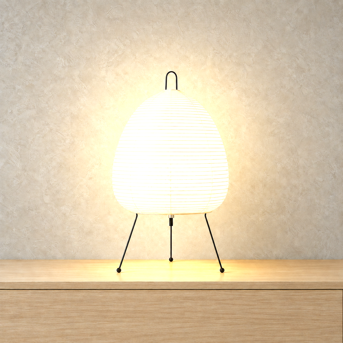 Lirveno white rice paper table lamp lit up against a warm greige plaster wall