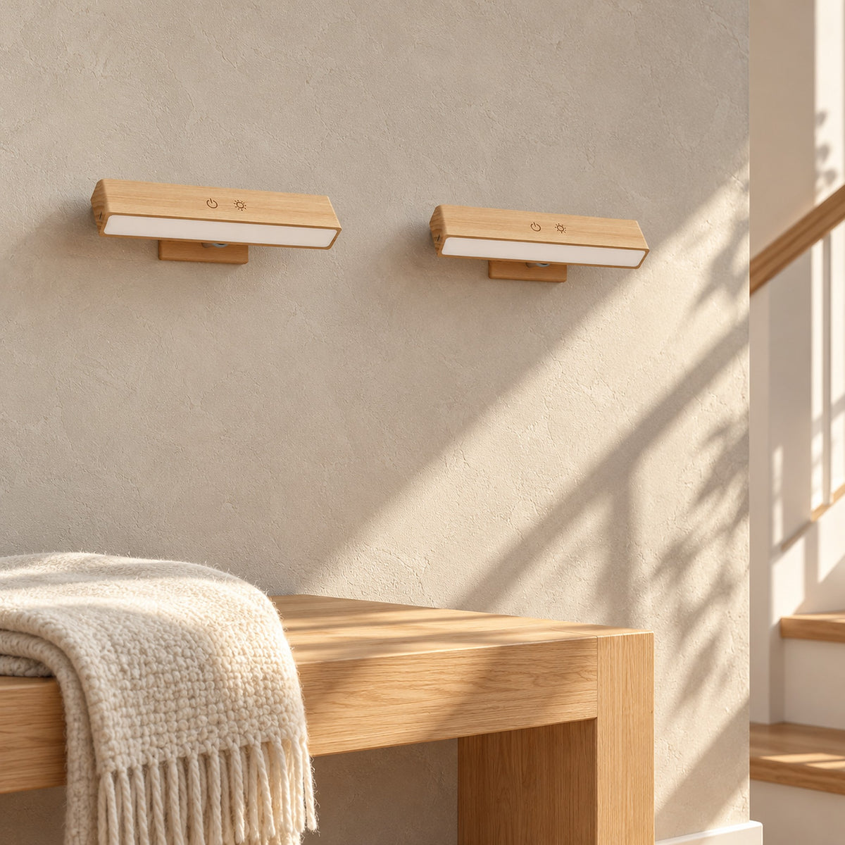 Lisomar main wireless wall light pair, switched off, on a sunlit stair landing wall