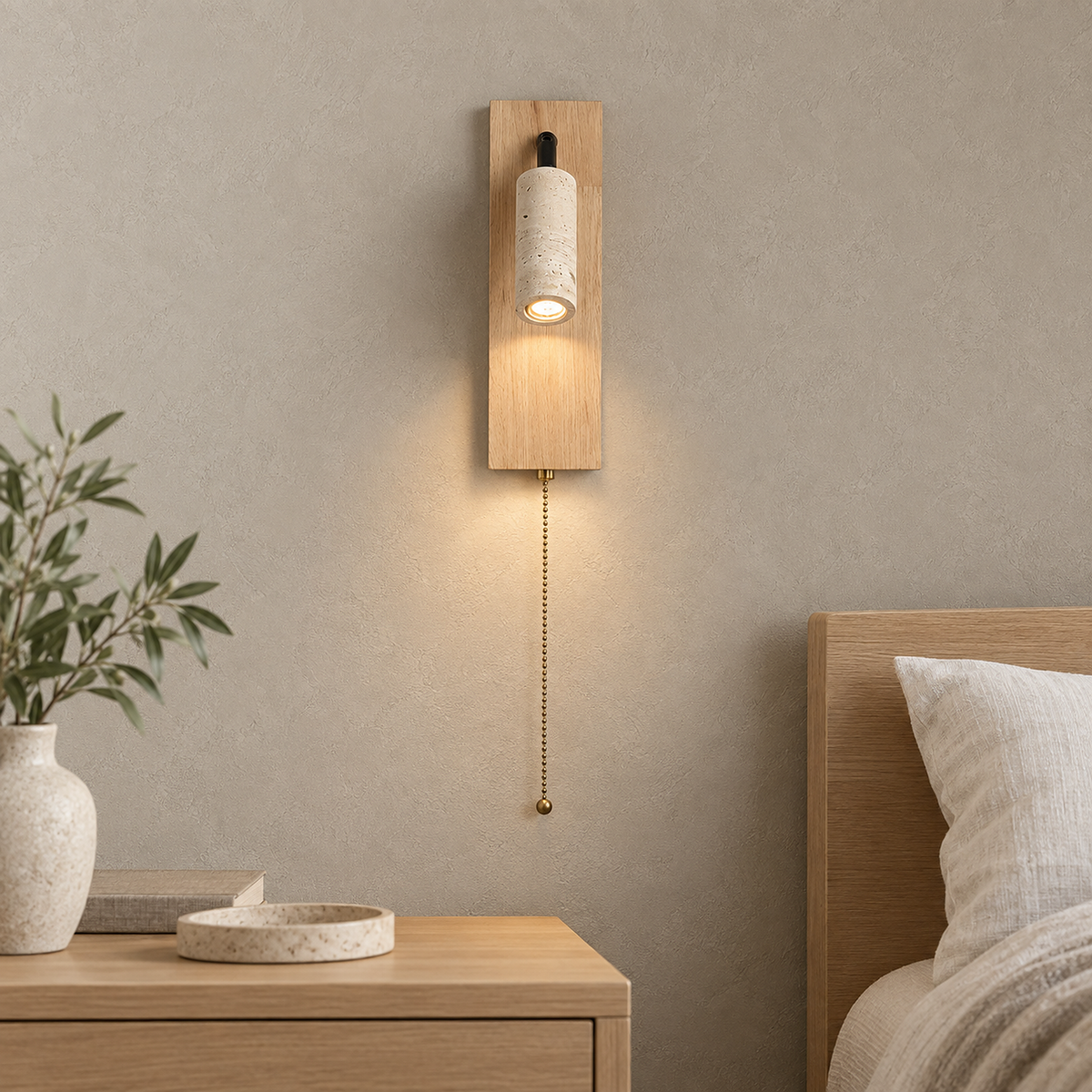 Lomarel wood bedside lamp lit showing its full hanging pull chain beside ivory bedding