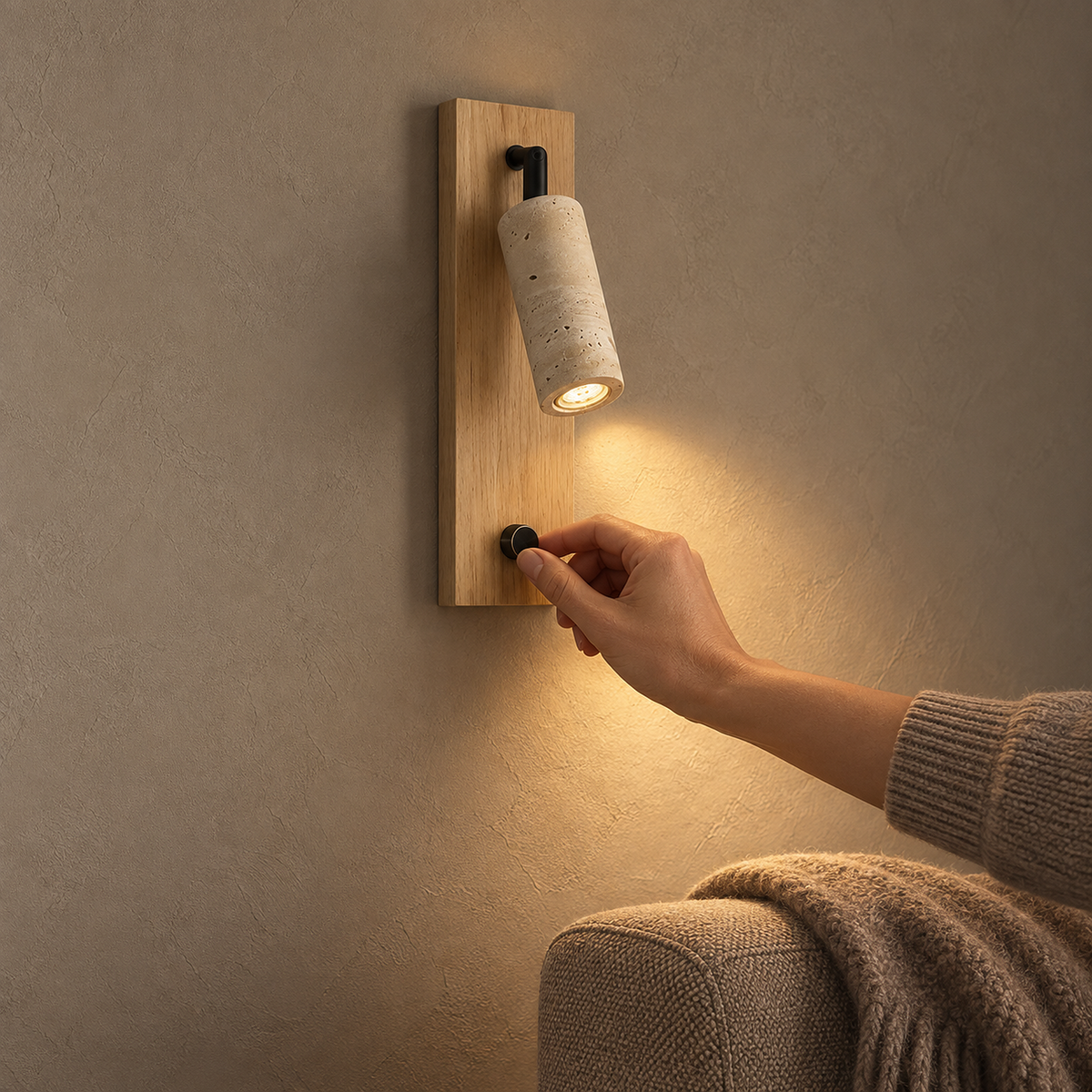 Lomarel wood LED wall sconce lit with a hand turning its dimmer switch control