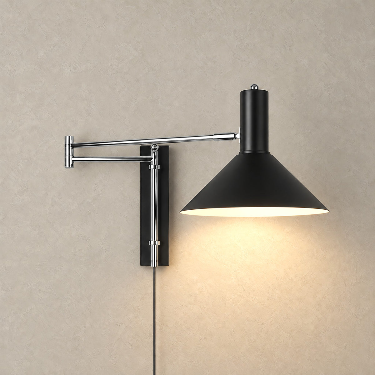 Lomaresi black wall sconce on a swing arm casting warm downward light across a plain wall