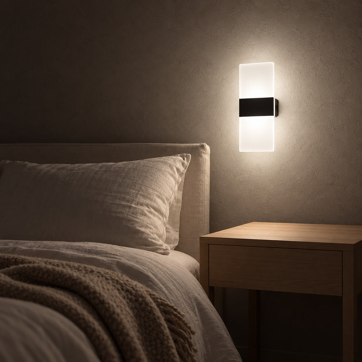 Melavor black bedside wall light washing the bedroom plaster with a soft glow after dark