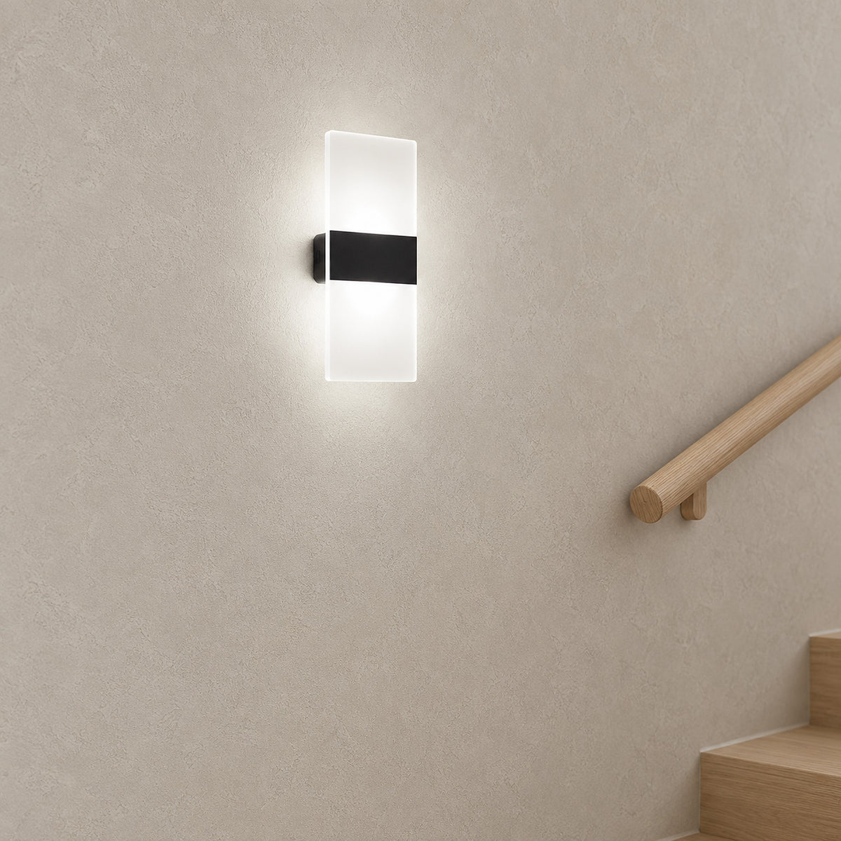 Melavor black wall lamp glowing on a stair landing, mounted beside the handrail