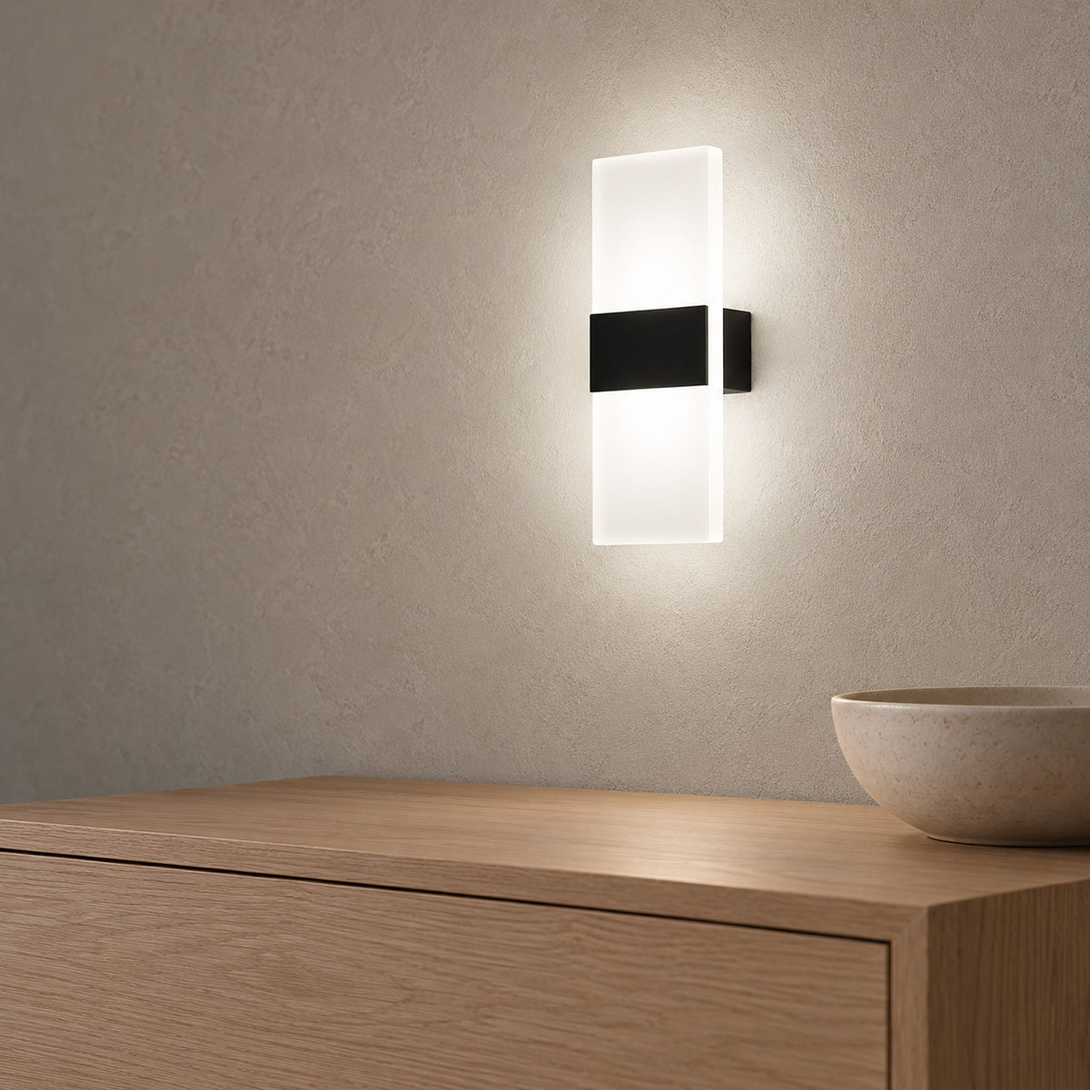 Melavor black wall lamp lit in a dining room, seen from the right side