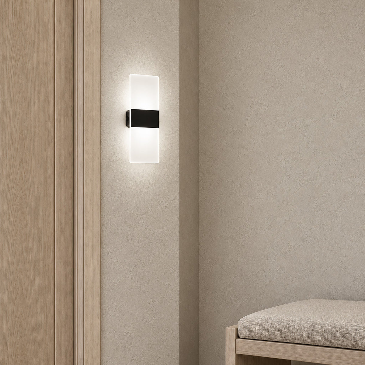 Melavor black wall sconce lit on a narrow pier in the entry vestibule