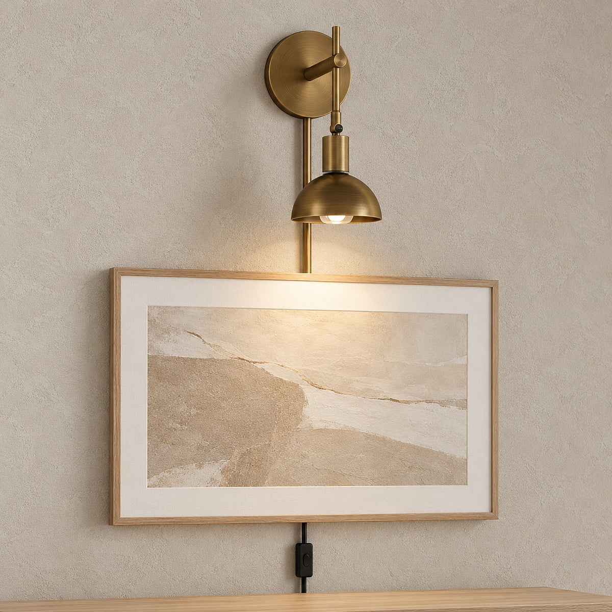 Melcasi plug in led wall sconce with antique brass colored shade lighting artwork in an entryway by day