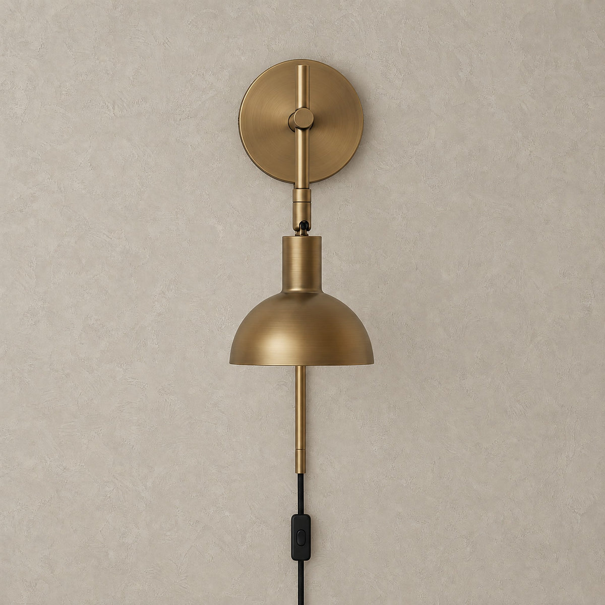 Melcasi plug in led wall sconce with antique brass colored metal shade and circular backplate shown unlit