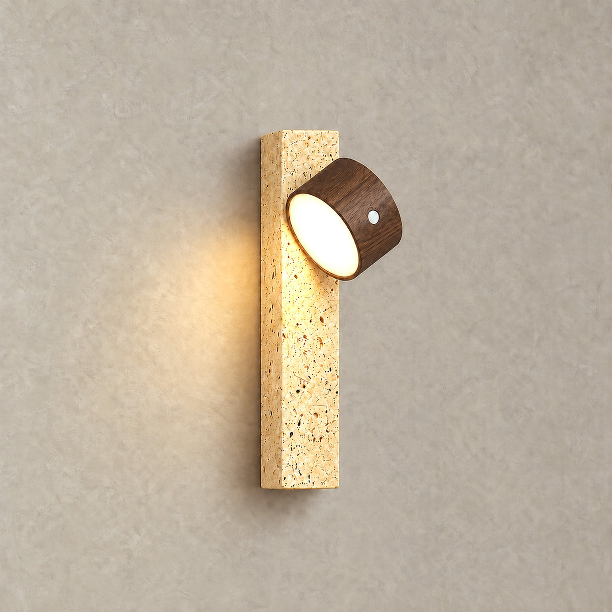 Mernavo dark wood and yellow travertine LED wall sconce glowing warm against a plaster wall