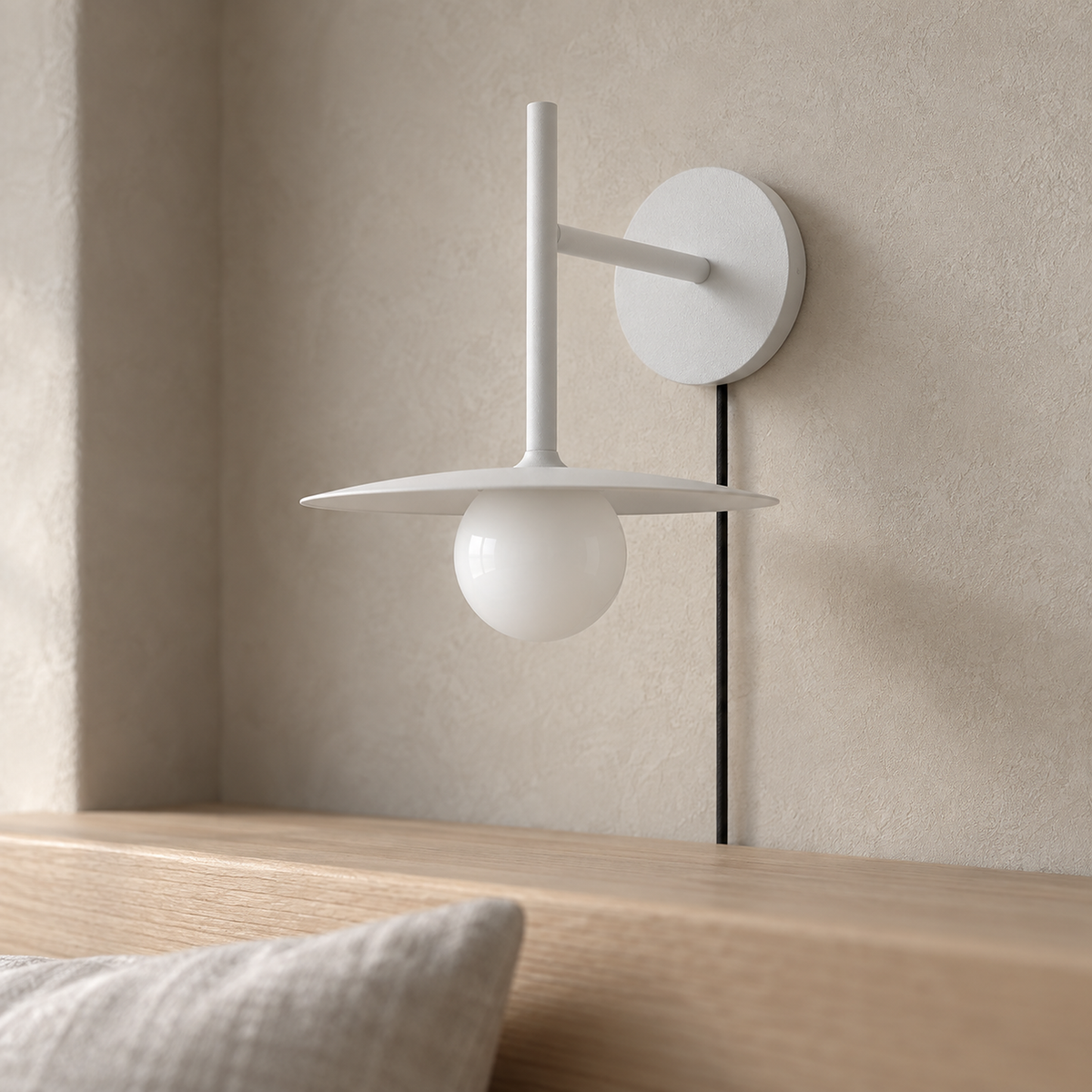 Milvaro white plug in wall sconce in close daylight detail of the metal disc and glass globe