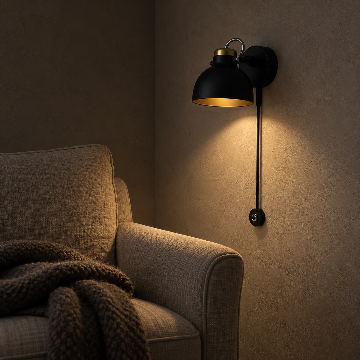 Miralote black wall sconce making a small pool of light beside a library chair at night