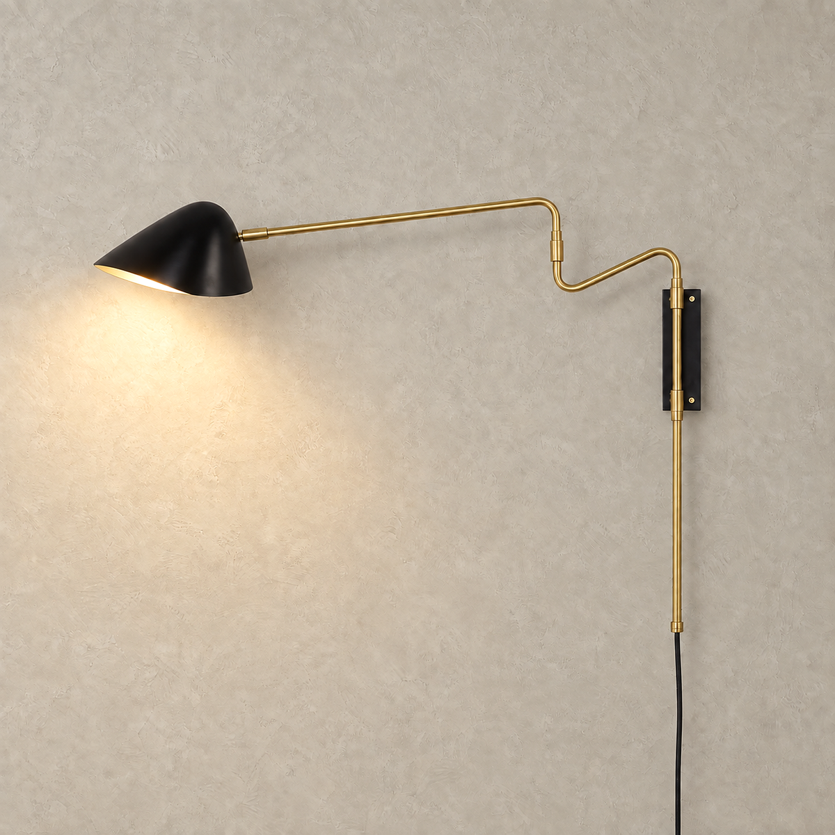 Movresa black bedside wall light glowing against a greige plaster wall