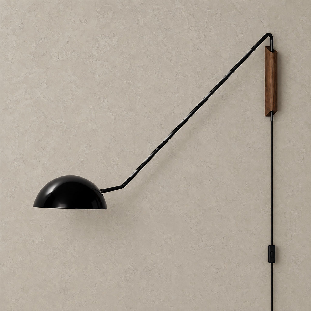 Nalesio black plug in wall lamp shown unlit against greige plaster with its metal dome shade and swing arm