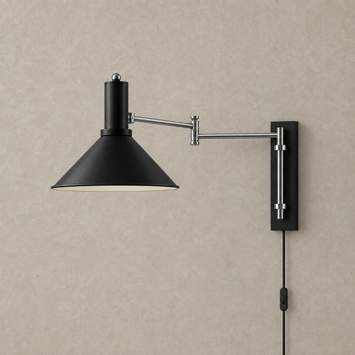 Navellir matte black swing arm wall sconce unlit on a plain plate with its silver arm extended